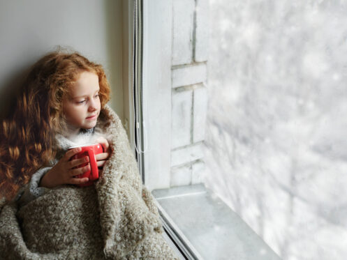Little girl sitting next to a window in Foley, AL